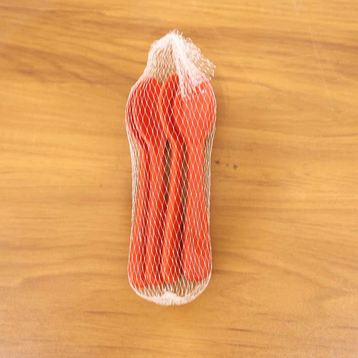 Five plastic spoons displayed on a wooden table