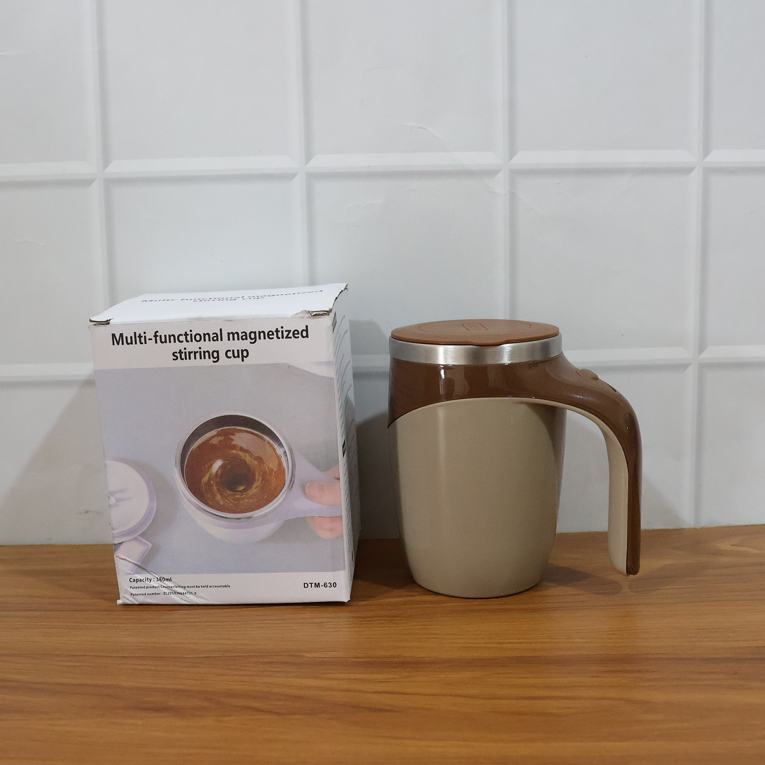 Person holding a self-stirring coffee mug