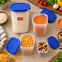An overhead view of four clear plastic containers with blue lids, some open, holding different foods on a kitchen surface.