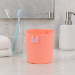Toothbrush holder mounted on a bathroom wall, showing adhesive