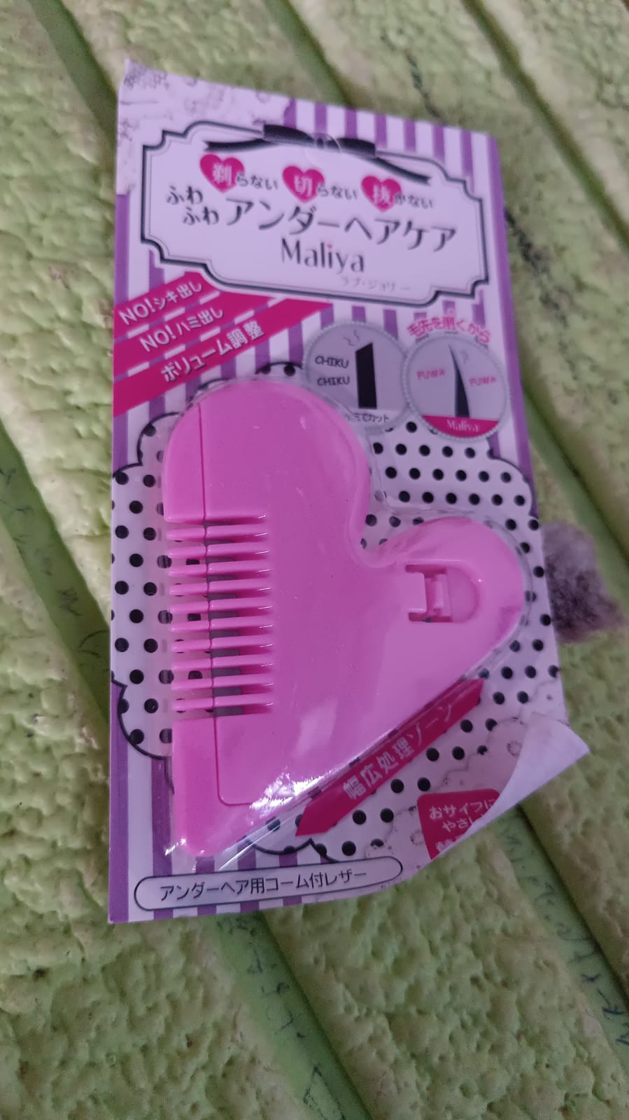 Heart shape plastic hair scissors in user's hand for scale
