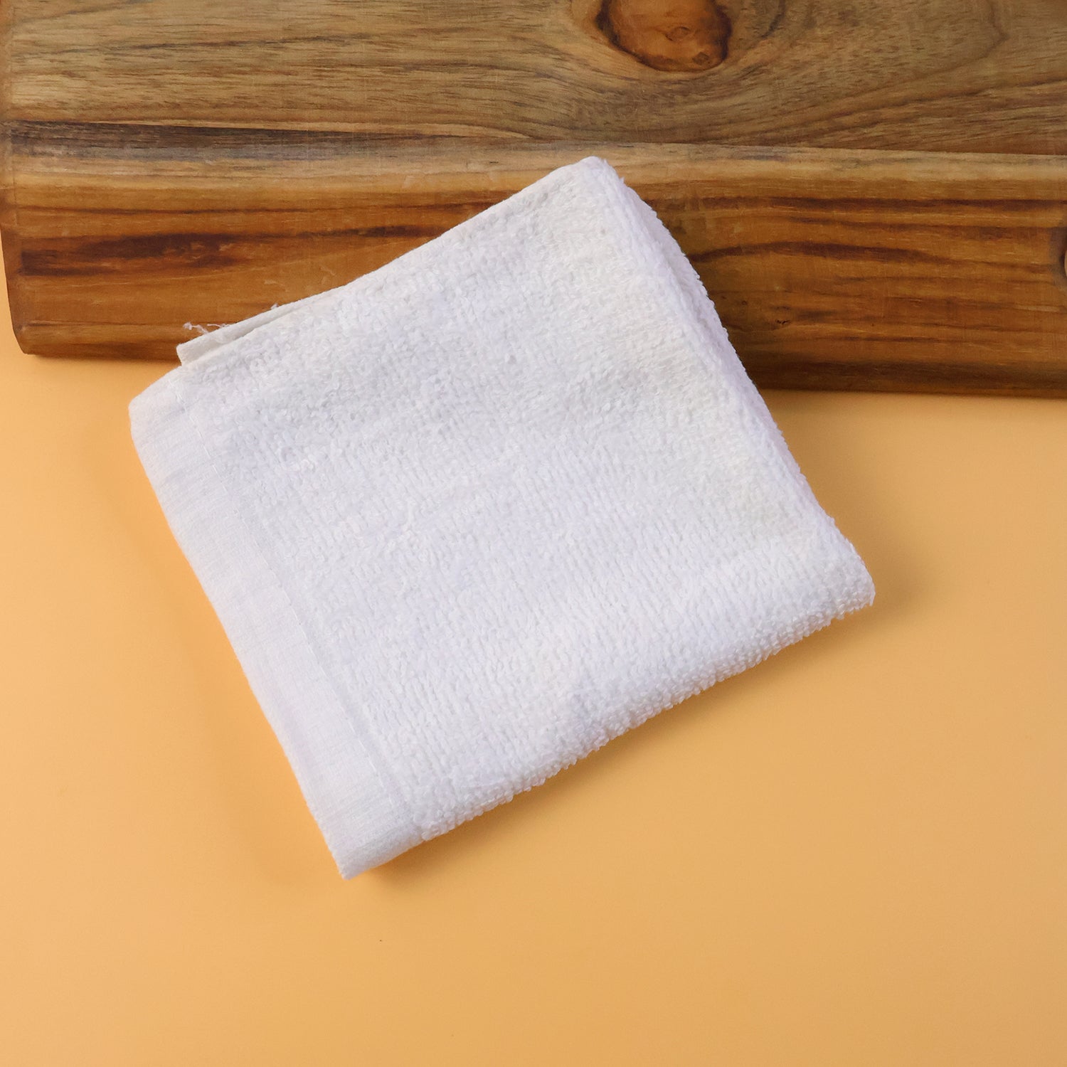 Microfiber cleaning cloth folded next to cleaning spray bottle