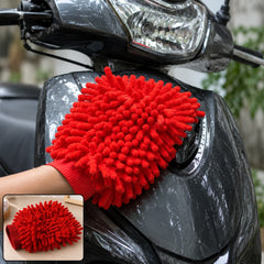 A person's hand in a red microfiber chenille wash glove cleaning the dark gray body of a scooter.