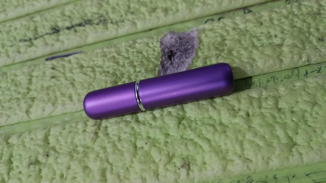 Mini portable perfume spray in hand