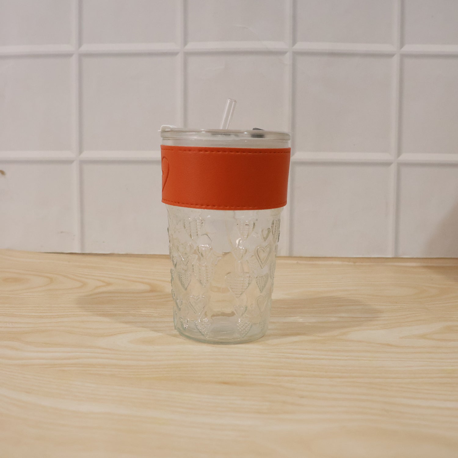 Hand holding glass tumbler with lid, ready for daily use