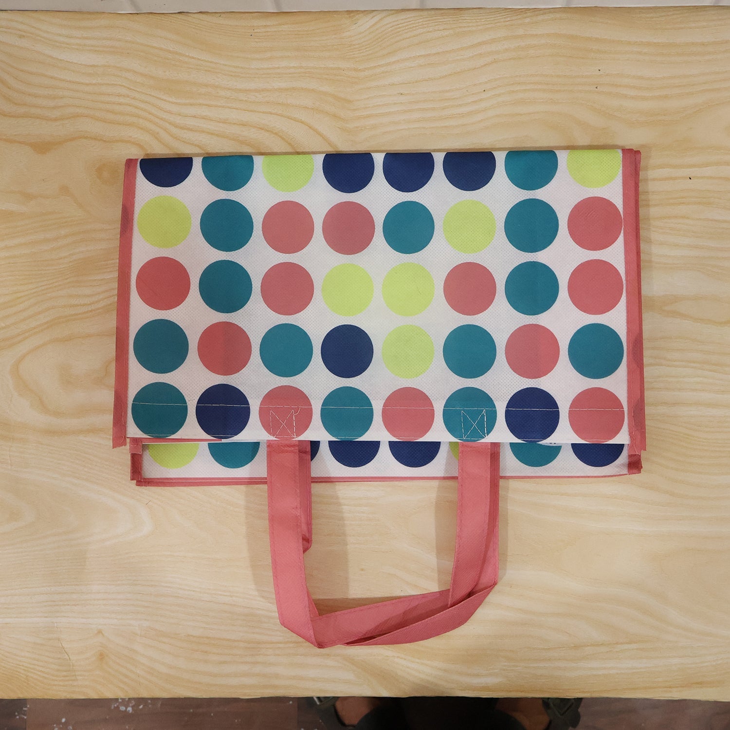 Person carrying a large printed shopping bag