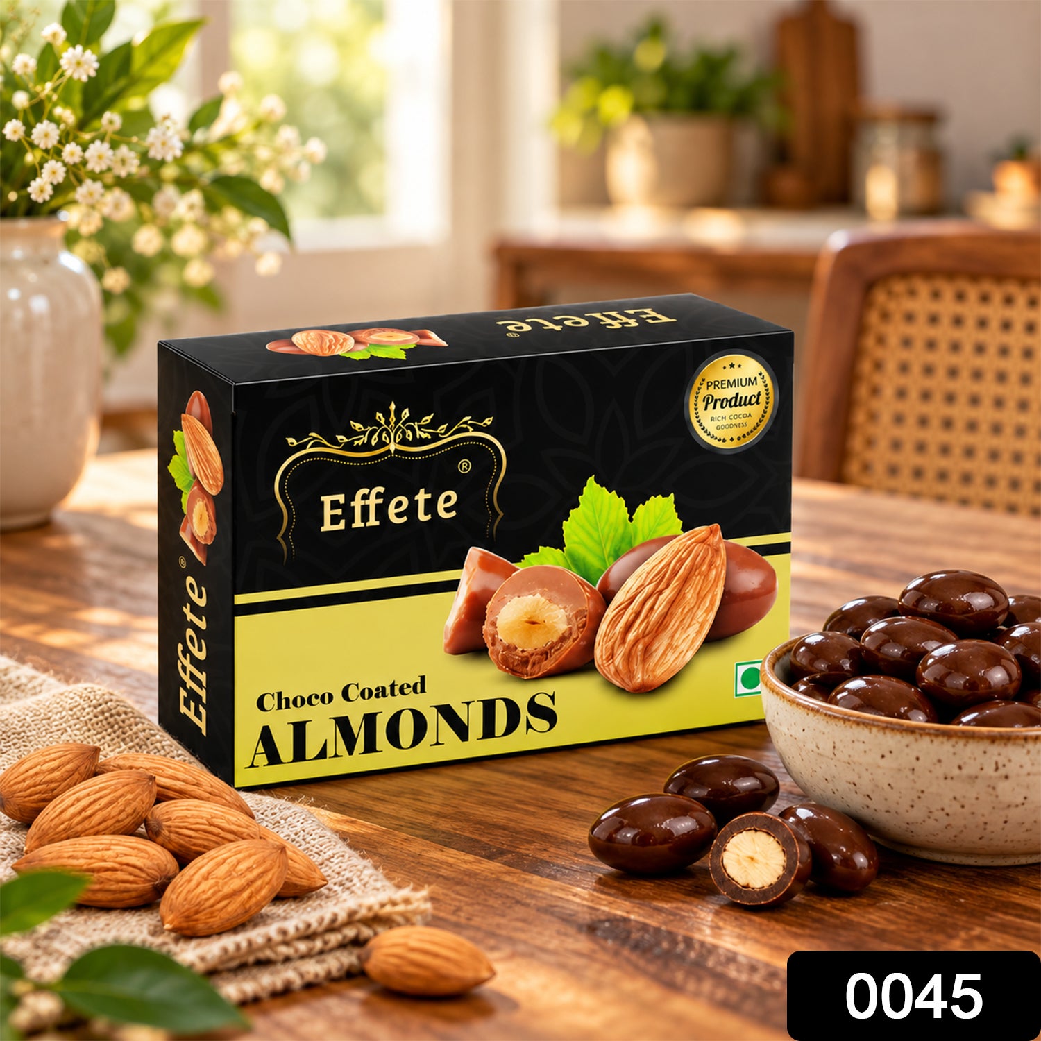 A black and yellow box of Effete Choco Coated Almonds sits on a wooden table with loose almonds and a bowl of â€“ view 3