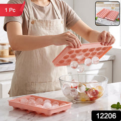 A person in an apron holds a pink ice ball tray, releasing clear ice balls into a glass bowl of fruit, with a '1 Pc' label.