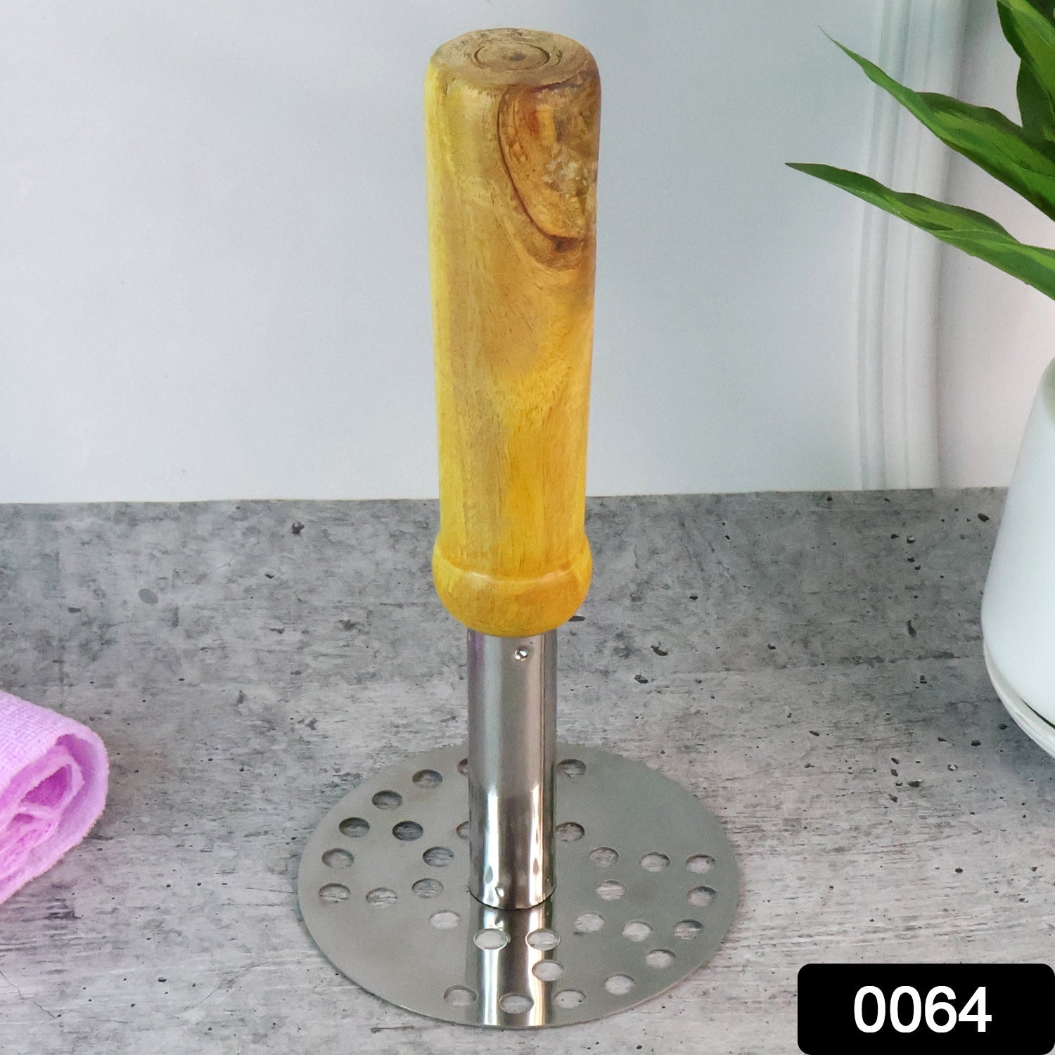 Potato masher with ergonomic wooden handle being held