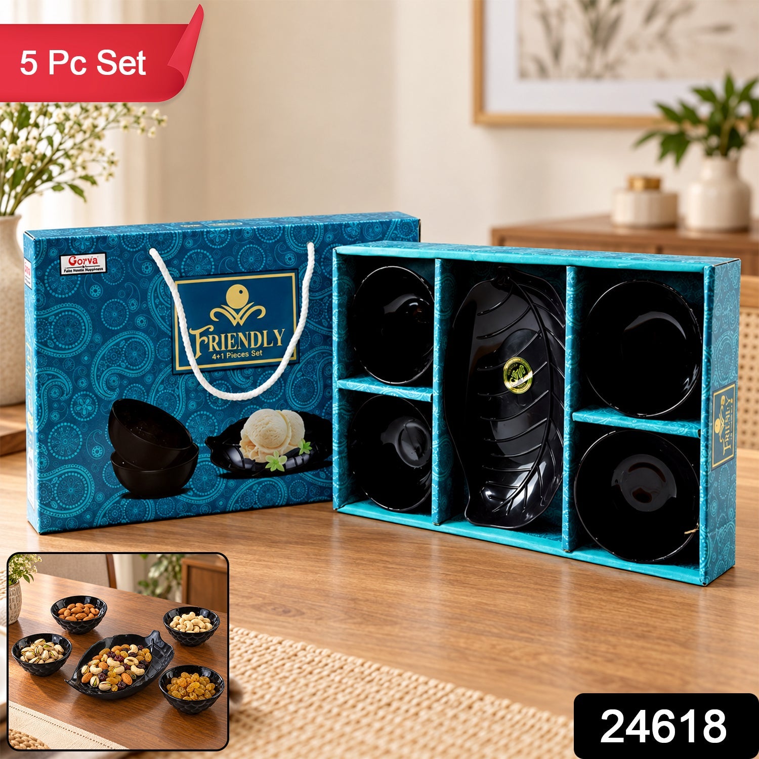 A blue patterned gift box containing a black leaf-shaped platter and four black bowls is on a wooden table.