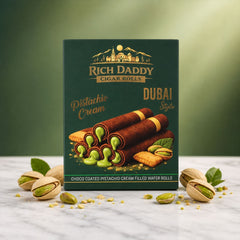 Green box of Rich Daddy Cigar Rolls, with pistachios scattered on a white marble surface.